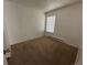 A simple carpeted bedroom has neutral colors and a window for natural light at 3577 S Ouray Cir, Aurora, CO 80013
