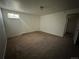 A simple carpeted bedroom has neutral colors and a window for natural light at 3577 S Ouray Cir, Aurora, CO 80013