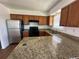 Kitchen featuring wooden cabinets, stone countertops, and stainless steel appliances at 3577 S Ouray Cir, Aurora, CO 80013