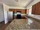 Kitchen featuring wooden cabinets, stone countertops, and stainless steel appliances at 3577 S Ouray Cir, Aurora, CO 80013