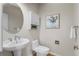 Clean half bathroom with a pedestal sink, toilet, and decorative art at 21548 E Ottawa Cir, Aurora, CO 80016