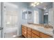 Bathroom with double sinks, large mirror, and adjacent bathroom at 21548 E Ottawa Cir, Aurora, CO 80016