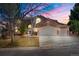 Stunning brick home featuring a 3-car garage, well-manicured lawn, and mature trees against a vibrant sunset sky at 21548 E Ottawa Cir, Aurora, CO 80016