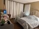 Bedroom with blue floral bedding, a desk area, and soft, sheer curtains at 3750 S Fairplay Way, Aurora, CO 80014