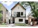 Charming two-story home with a striking white facade, balcony, and black trim at 3926 Kalamath St, Denver, CO 80211