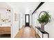 Bright hallway with wood floors and decor leading to bathroom with unique wallpaper at 3926 Kalamath St, Denver, CO 80211