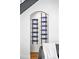Modern wine rack with arch design embedded in wall and holding blue glass bottles at 3926 Kalamath St, Denver, CO 80211