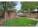 Beautiful backyard with a well-manicured lawn, garden beds, and a brick-accented garage at 726 S Corona St, Denver, CO 80209