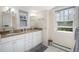 Bathroom with dual sinks, granite countertops, white cabinets, and natural light from multiple windows at 726 S Corona St, Denver, CO 80209