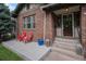 Inviting covered brick front porch with red chairs and a lantern, adding a touch of warmth at 726 S Corona St, Denver, CO 80209