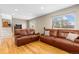 Living room with wood floors, two leather couches, and a window at 6782 Hills Dr, Parker, CO 80138