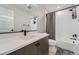 Comfortable full bathroom with a sink and vanity, toilet, and shower-tub combo with tile surround and neutral decor at 16433 Askins Loop, Parker, CO 80134