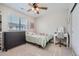 Cozy bedroom features a ceiling fan, gray dresser, desk with vanity mirror, and window with blinds at 16433 Askins Loop, Parker, CO 80134