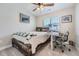 Functional bedroom featuring a wood-framed bed, a ceiling fan, neutral carpet, and a desk space with a modern chair at 16433 Askins Loop, Parker, CO 80134