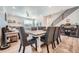 Stylish dining area featuring a large table with seating, hardwood floors, and a view of the modern staircase at 16433 Askins Loop, Parker, CO 80134