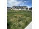 Townhome community showcasing modern architecture, stone accents, and a spacious green common area at 16433 Askins Loop, Parker, CO 80134