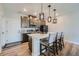 Well-lit kitchen featuring a quartz island with seating, modern lighting, and stainless steel appliances at 16433 Askins Loop, Parker, CO 80134