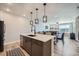 Open floor plan showing the kitchen island flowing into the dining and living room area at 16433 Askins Loop, Parker, CO 80134