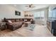 Comfortable living room with a large sectional couch, wood-look flooring, and lots of natural light at 16433 Askins Loop, Parker, CO 80134