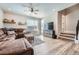Cozy living room with a large couch, wood-look floors, and access to the staircase at 16433 Askins Loop, Parker, CO 80134