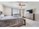 Bright main bedroom featuring a large window, wooden dresser, ceiling fan, and neutral carpet, creating a serene retreat at 16433 Askins Loop, Parker, CO 80134