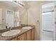 Bathroom featuring dual sinks, granite countertops, a large mirror, and an enclosed shower at 12421 Irving Dr, Broomfield, CO 80020