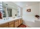 Bathroom with double vanity, large mirror and a soaking tub at 180 Cook St # 105, Denver, CO 80206