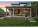 Covered back patio complete with outdoor seating, dining area and lush green grass at 5528 S Jasper Way, Centennial, CO 80015