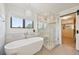 Spa-like bathroom with freestanding tub, glass shower, and stylish light fixture at 5528 S Jasper Way, Centennial, CO 80015