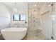 Modern bathroom featuring a soaking tub, walk-in shower with bench, and stylish marble tile at 5528 S Jasper Way, Centennial, CO 80015