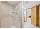 Tile shower with shelves and glass door in a modern bathroom at 5528 S Jasper Way, Centennial, CO 80015