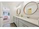 Stylish bathroom featuring dual sinks, round mirrors, and modern lighting at 5528 S Jasper Way, Centennial, CO 80015