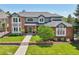 Inviting two-story home featuring a brick and gray exterior, manicured lawn and mature landscaping at 5528 S Jasper Way, Centennial, CO 80015
