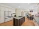 Bright kitchen features a center island with cooktop, white cabinets and a seamless flow into the dining area at 5528 S Jasper Way, Centennial, CO 80015