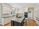 Modern kitchen featuring white cabinets, dark countertops, an island with seating, and stainless steel appliances at 5528 S Jasper Way, Centennial, CO 80015