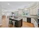 Open kitchen with a spacious island, stainless steel appliances, and seamless access to the living areas at 5528 S Jasper Way, Centennial, CO 80015