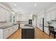 Spacious kitchen features white cabinets, stainless steel appliances and a large center island with built in cooktop at 5528 S Jasper Way, Centennial, CO 80015