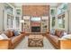 Cozy living room with a brick fireplace, built-in bookshelves, and large windows at 5528 S Jasper Way, Centennial, CO 80015
