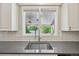 Kitchen sink with modern faucet and white subway tile backsplash and view to the covered deck at 5528 S Jasper Way, Centennial, CO 80015