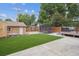 Large backyard includes a detached garage and trampoline with a manicured lawn and patio at 2664 Forest St, Denver, CO 80207