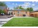 Spacious backyard featuring a well-maintained lawn and a charming brick home exterior at 2664 Forest St, Denver, CO 80207