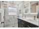 Updated bathroom featuring marble tile, glass shower, double vanity with gold fixtures at 2664 Forest St, Denver, CO 80207