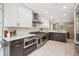 Bright kitchen boasts stainless appliances, white cabinets, tile backsplash, and modern fixtures at 2664 Forest St, Denver, CO 80207
