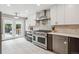 Modern kitchen features stainless appliances, white cabinets, tile backsplash, access to a private backyard space at 2664 Forest St, Denver, CO 80207