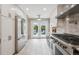 Bright kitchen with stainless steel appliances, white cabinetry, and access to a cozy backyard at 2664 Forest St, Denver, CO 80207