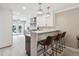 Bright kitchen boasts white cabinets, stainless steel appliances, quartz counters and a breakfast bar with seating at 2664 Forest St, Denver, CO 80207