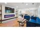 Open-concept living room with hardwood floors, an electric fireplace, comfortable seating, and seamless transition to the kitchen at 2664 Forest St, Denver, CO 80207