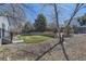 Landscaped backyard featuring a stone retaining wall, grass, and a variety of trees and plants at 20344 Heather Ln, Parker, CO 80138
