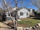 Exterior view of the home with a deck and a large backyard with mature trees and landscaping at 20344 Heather Ln, Parker, CO 80138