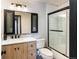 Well-lit bathroom featuring a modern vanity, stylish mirror, and glass-enclosed shower at 2700 S Holly St # 202, Denver, CO 80222